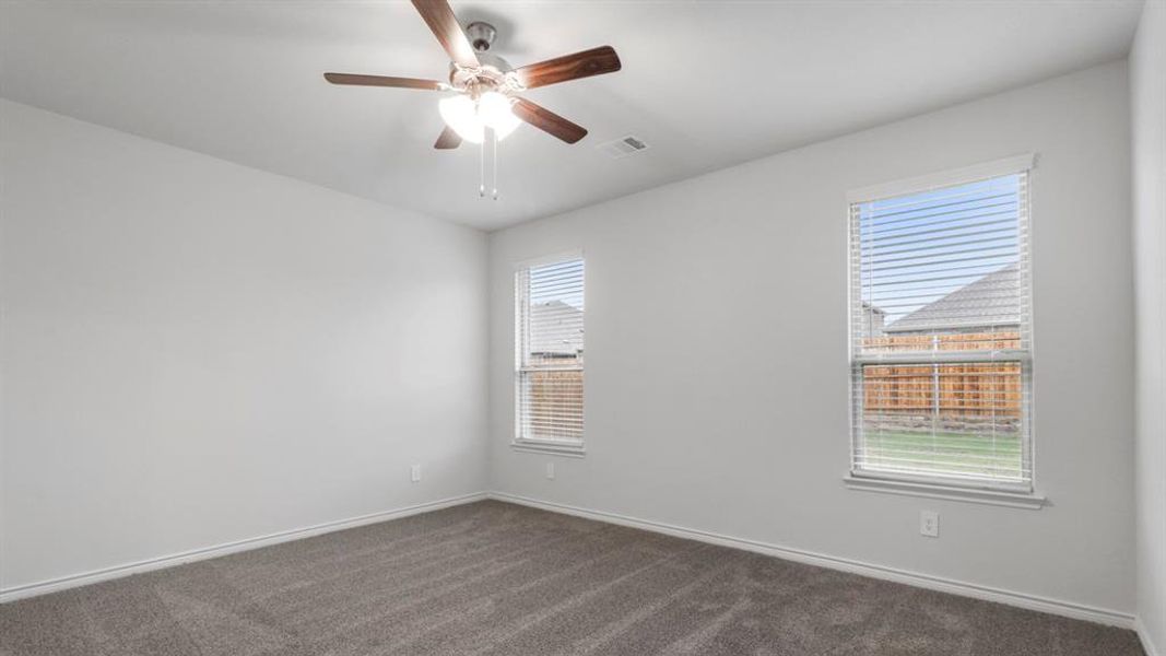Spare room with dark colored carpet and a ceiling fan