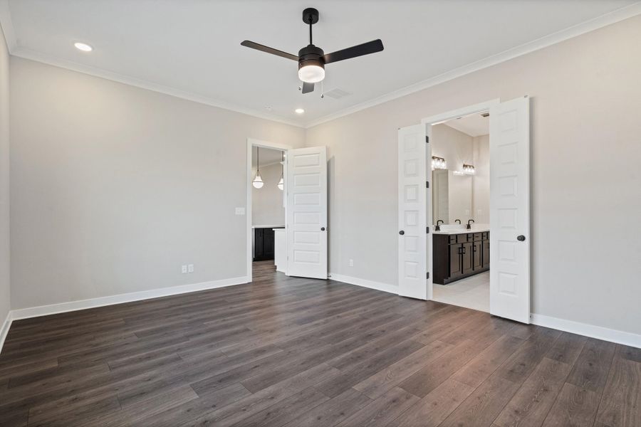 Unfurnished bedroom with crown molding, a ceiling fan, dark wood-style floors, ensuite bathroom, and recessed lighting
