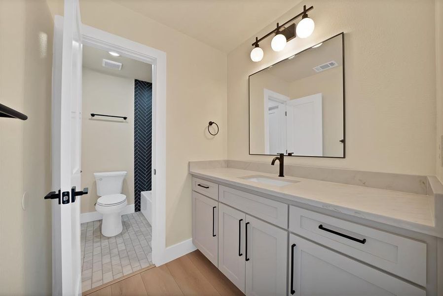 Bathroom featuring vanity, light tile patterned flooring, and shower / bath combo with shower curtain Bathroom featuring vanity, light tile patterned flooring, and shower / bath combo with shower curtain