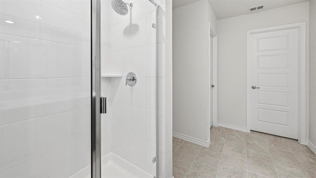 Bathroom featuring a stall shower and light tile patterned floors