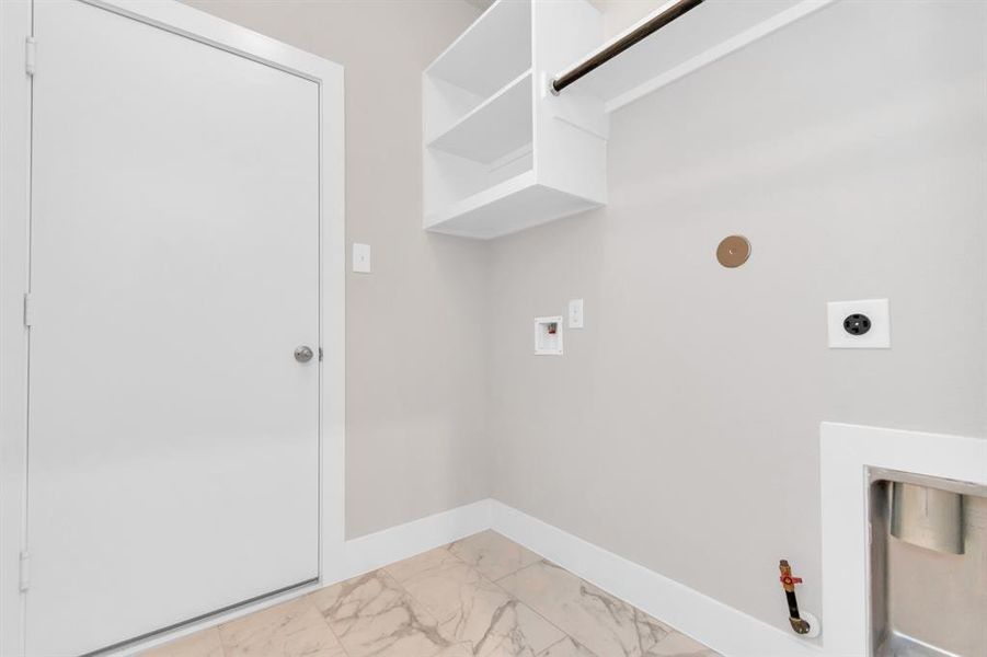 A perfect blend of functionality and comfort. Laundry room, thoughtfully equipped with shelving for effortless organization. Both gas and electric connections available. Sample photo of completed home. Actual colors and selections may vary.