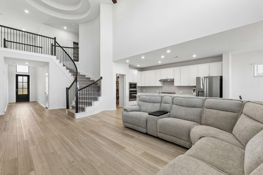 Designed with an open-concept flow, the expansive family room serves as a grand retreat that connects seamlessly to the kitchen, creating an ideal layout for hosting guests. The modern lighting fixtures enhance the home’s sense of comfort and warmth.