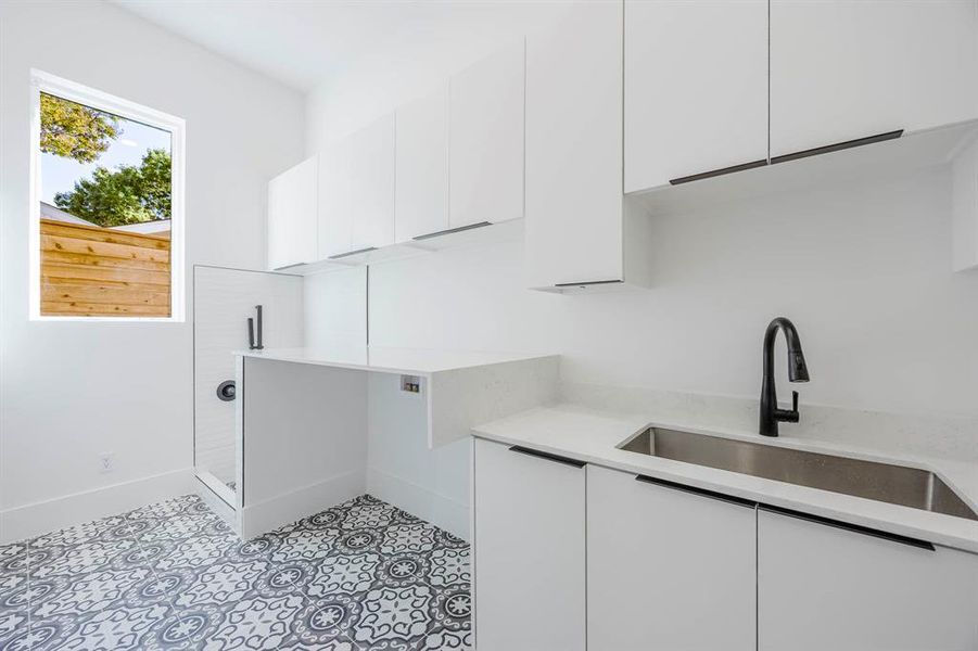 Laundry area with cabinet space and light tile patterned flooring Laundry area with cabinet space and light tile patterned flooring