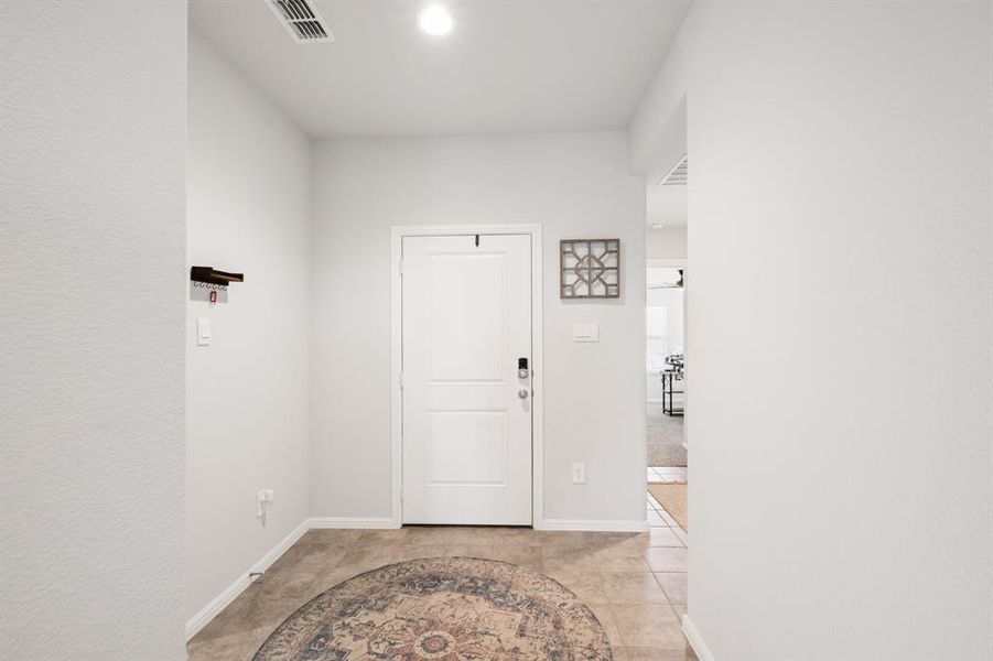 Entryway with baseboards and light tile patterned floors