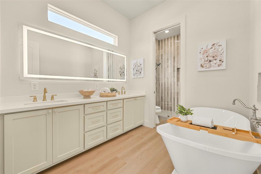 Spacious Primary Bathroom with soaking tub, double sink vanity, large LED mirror, Quartz counter and brushed gold brass hardware. Spacious Primary Bathroom with soaking tub, double sink vanity, large LED mirror, Quartz counter and brushed gold brass hardware.