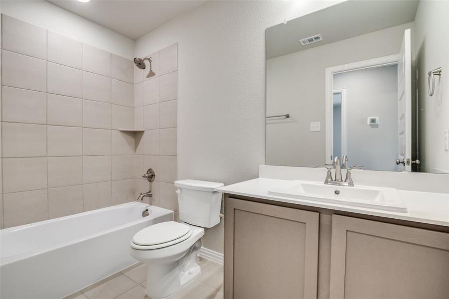 Bathroom with washtub / shower combination, vanity, and light tile patterned flooring Bathroom with washtub / shower combination, vanity, and light tile patterned flooring