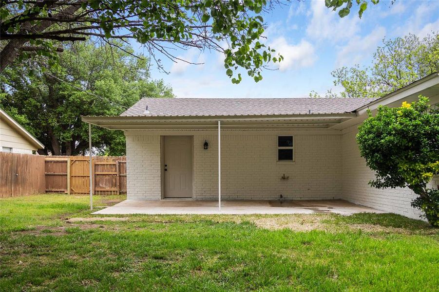 Back of property featuring a yard, a patio area, and brick siding Back of property featuring a yard, a patio area, and brick siding