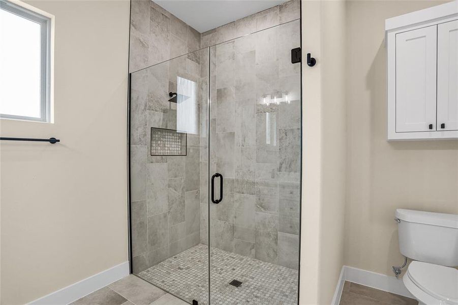 Full bath with a stall shower and tile patterned flooring Full bath with a stall shower and tile patterned flooring