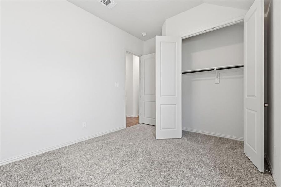 Unfurnished bedroom featuring light carpet and a closet