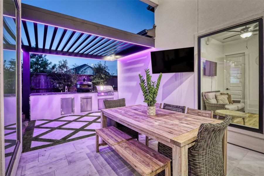 Custom lighting over the outdoor kitchen coordinates with the lighting over the pool and can be controlled via phone, and set to music.