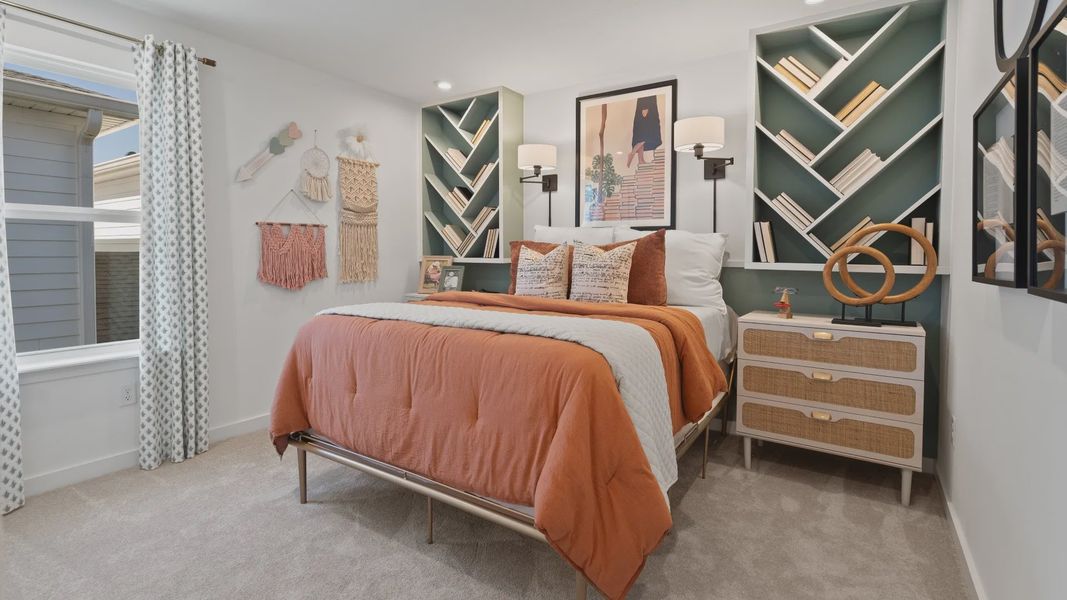 Carpeted secondary bedroom with large window in a DRB Home Clementine model at the Trinity Place community.