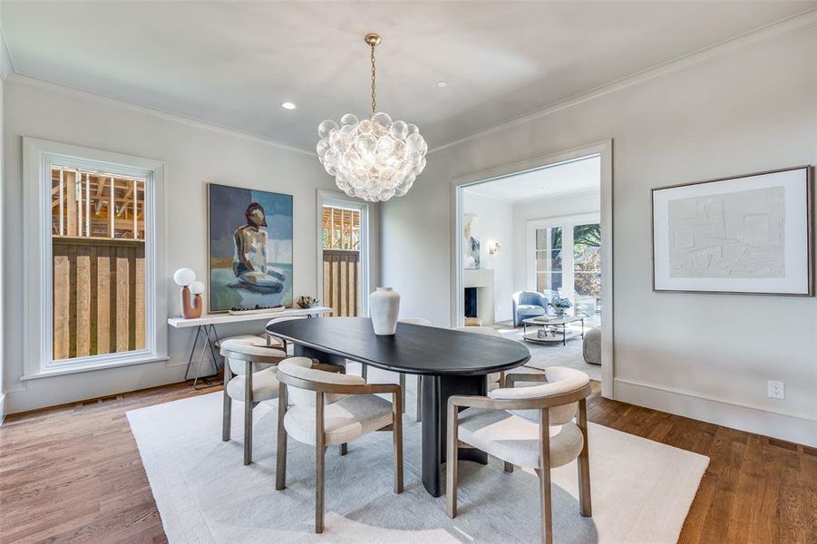 Dining space with a chandelier, wood finished floors, crown molding, and recessed lighting Dining space with a chandelier, wood finished floors, crown molding, and recessed lighting