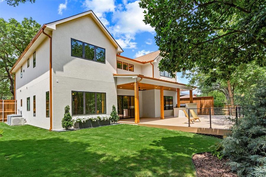 Rear view of property featuring stucco siding and a deck