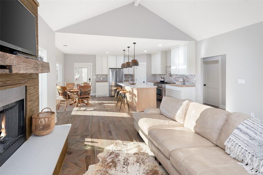 Living room featuring sink, light parquet floors, beamed ceiling, and high vaulted ceiling