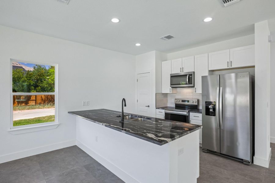 Bold stone countertops and sleek cabinetry anchor this modern culinary space.