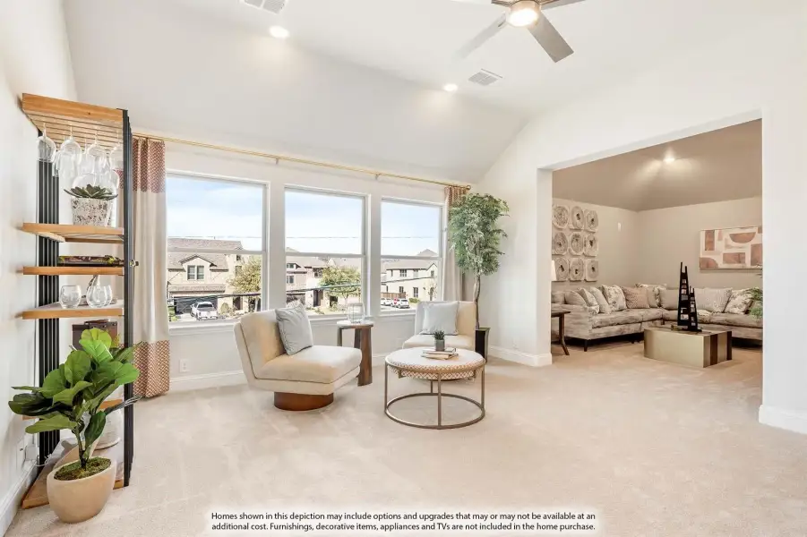Sitting room with vaulted ceiling, carpet flooring, large windows, and open view to adjacent living room