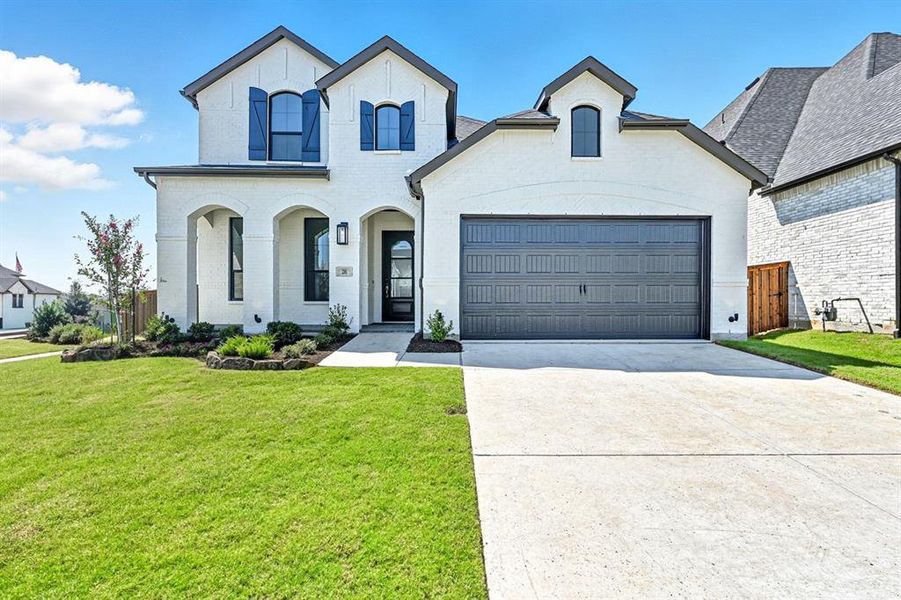 French country home with concrete driveway, brick siding, and a porch
