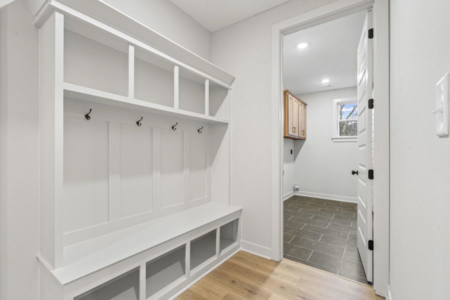 Built-in white storage bench with cubbies and coat hooks Built-in white storage bench with cubbies and coat hooks