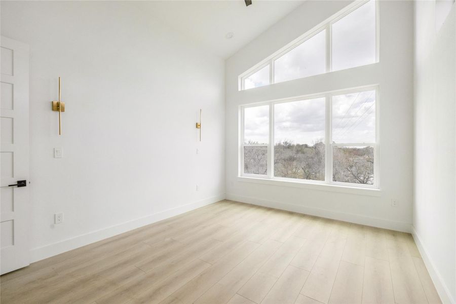 Spare room with lofted ceiling and light wood-style flooring