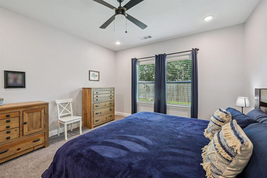 Bedroom with carpet, a ceiling fan, and recessed lighting Bedroom with carpet, a ceiling fan, and recessed lighting