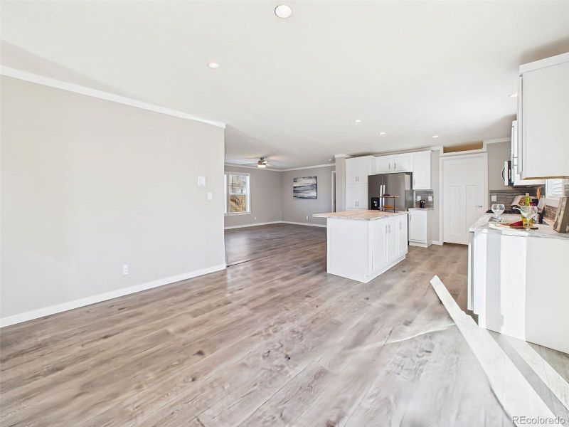 Unstaged Formal Dining Space – A blank canvas with abundant room for a formal dining setup or secondary living space, highlighted by modern lighting and wide-plank floors.