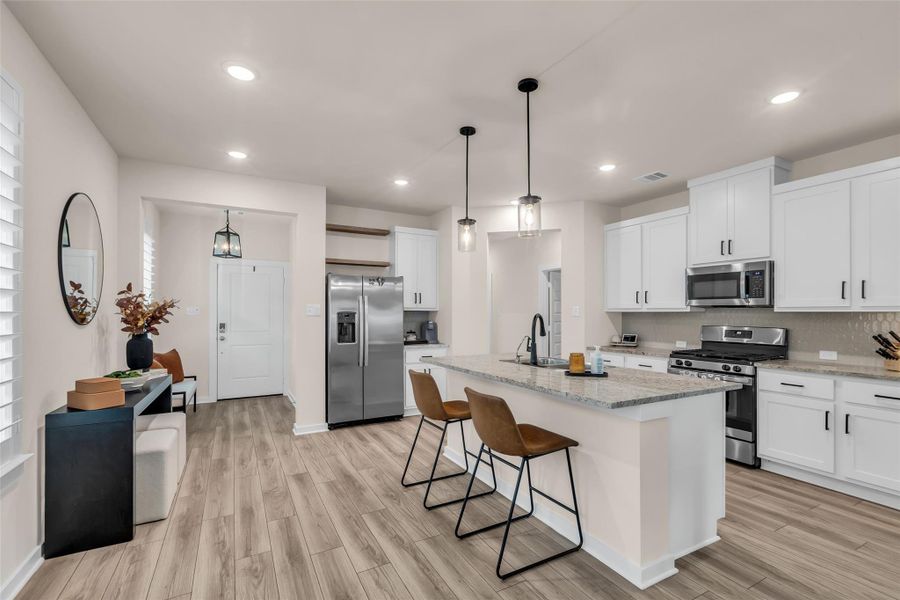 This modern kitchen features sleek white cabinets, stainless steel appliances, and a spacious island with bar seating. This modern kitchen features sleek white cabinets, stainless steel appliances, and a spacious island with bar seating.