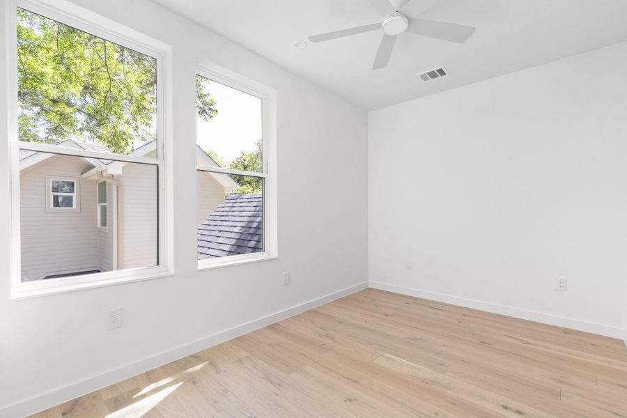 Empty room featuring light wood-style floors and ceiling fan Empty room featuring light wood-style floors and ceiling fan