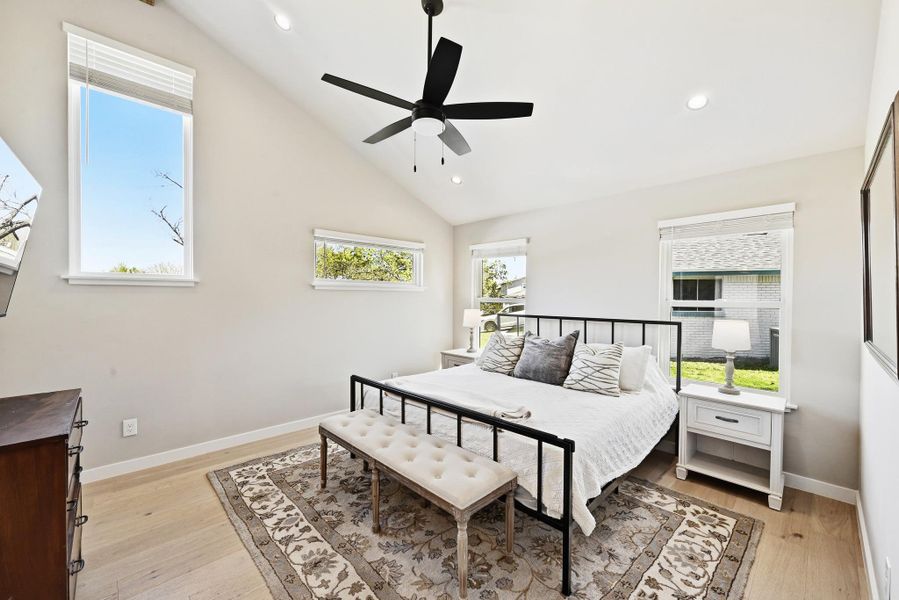 Bedroom with light wood-style floors, a ceiling fan, recessed lighting, and lofted ceiling