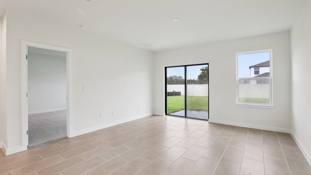 Naples Living area and sliding glass door to back yard at Grasslands West in Lakeland FL