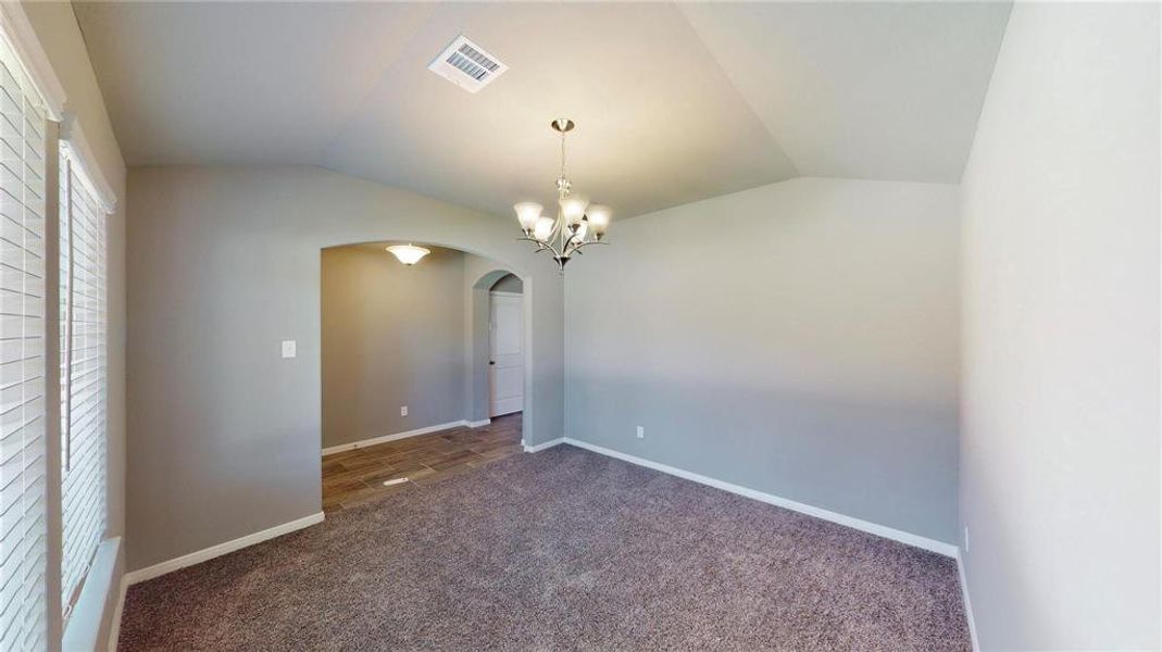 This versatile room can be used as a study or home office, featuring high ceilings and a large window that lets in plenty of natural light. The neutral tones and plush carpeting provide a calm and professional environment, perfect for productivity. The adjacent hallway leads to other areas of the home, ensuring easy access and a seamless flow. This is a picture of an Elise Floor Plan with another Saratoga Homes.