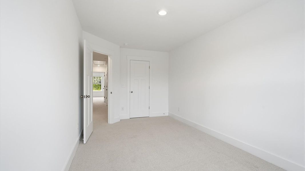 Tasteful bedroom with plush carpet, a walk-in closet, and large windows for abundant natural light in Greenville, SC Tasteful bedroom with plush carpet, a walk-in closet, and large windows for abundant natural light in Greenville, SC