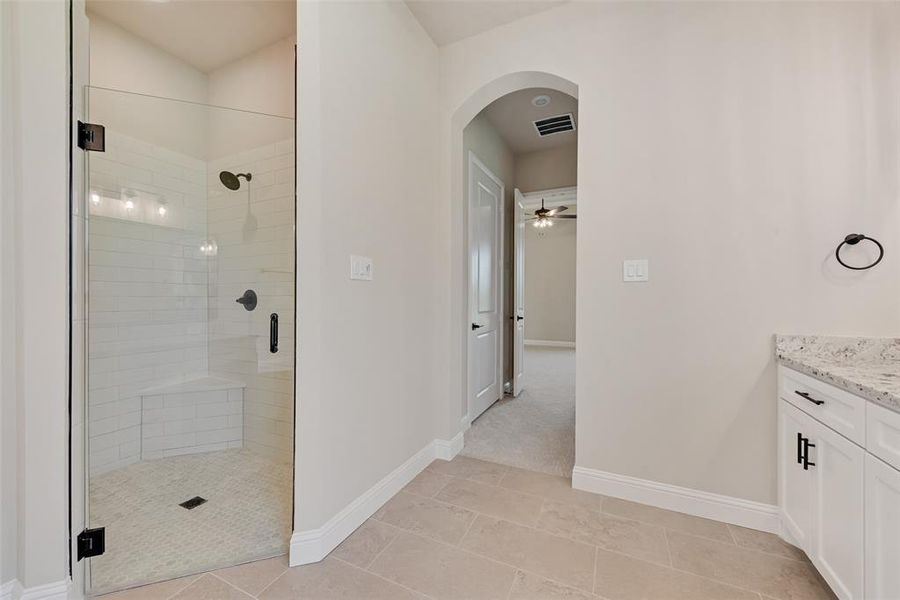 Full bath with a stall shower, vanity, tile patterned floors, and a ceiling fan