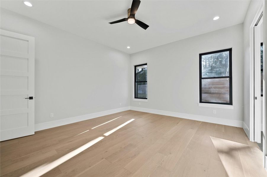 Empty room with ceiling fan, light hardwood / wood-style flooring, and a wealth of natural light