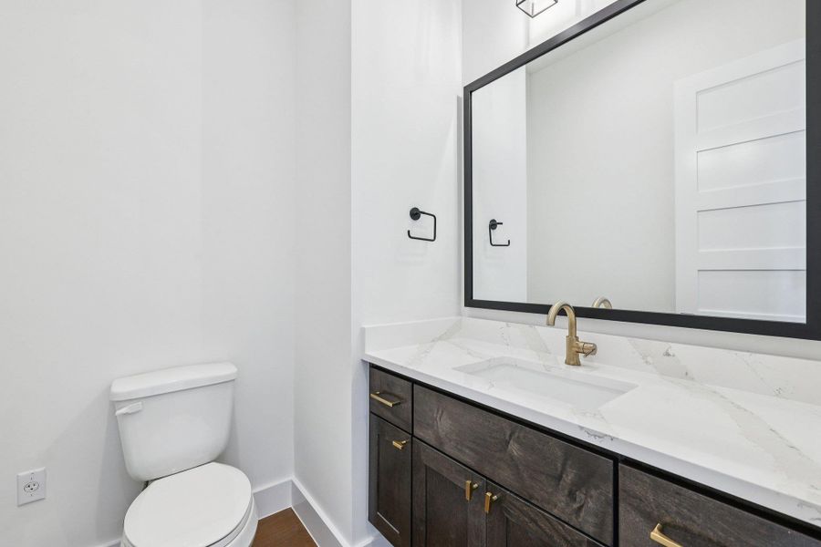 Half bath with vanity and baseboards