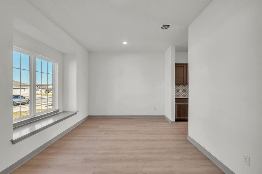 Empty room with light wood-style floors and recessed lighting