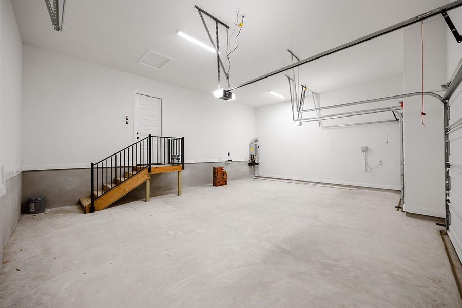 Garage featuring a garage door opener and water heater Garage featuring a garage door opener and water heater