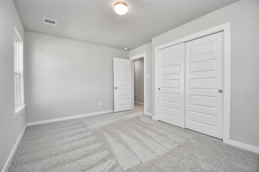 Generously sized secondary bedrooms featuring spacious closets, soft and inviting carpeting underfoot, large windows allowing plenty of natural light, and the added touch of privacy blinds for your personal retreat.