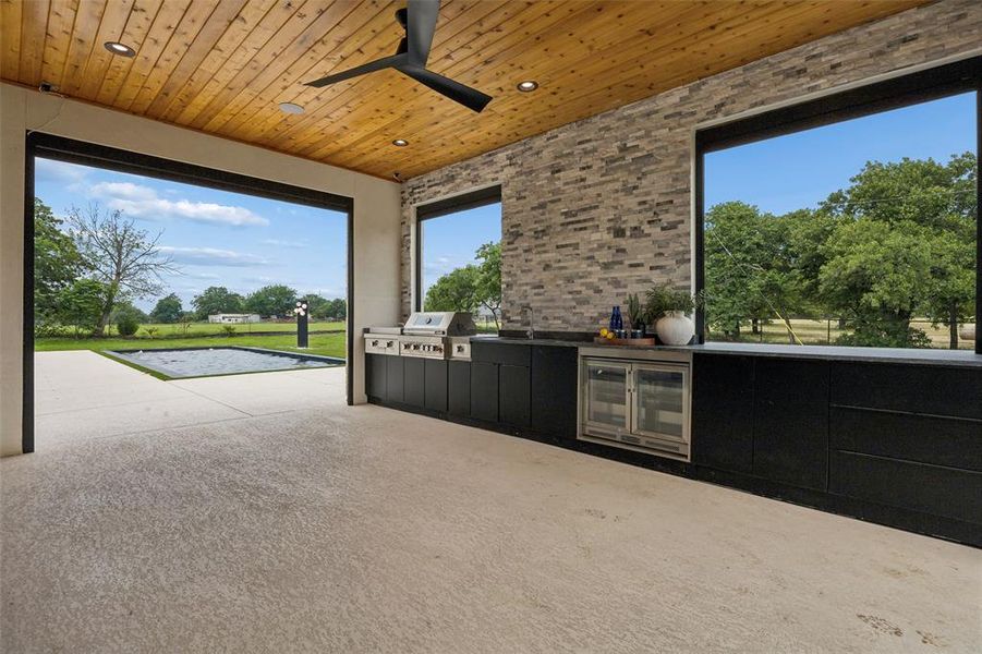 Large outdoor kitchen area with automatic shades.