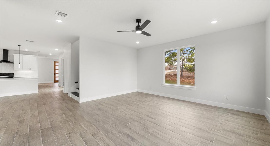 Unfurnished room featuring wood finish floors, stairway, recessed lighting, and a ceiling fan