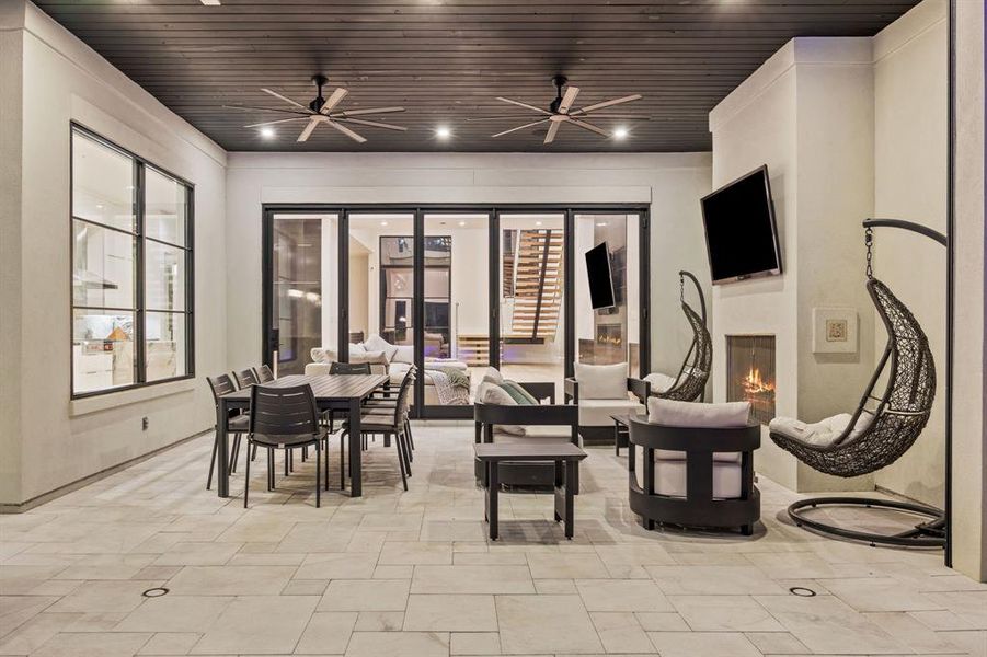 Back house at dusk featuring pool water feature, a patio area, a yard, and an outdoor living space with a fire pit