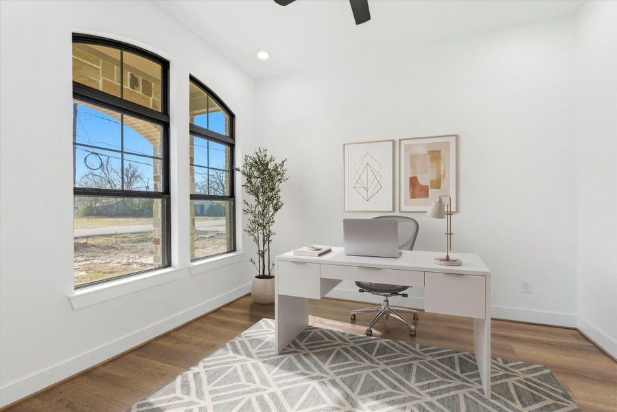 A dedicated first floor office features beautiful forward-facing windows, a ceiling fan, and recessed lighting—ideal for a bright, comfortable workspace.(Virtually Staged)