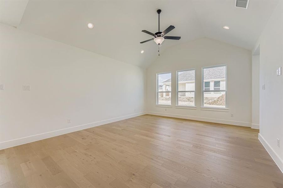 Spare room with light wood finished floors, recessed lighting, ceiling fan, and high vaulted ceiling Spare room with light wood finished floors, recessed lighting, ceiling fan, and high vaulted ceiling