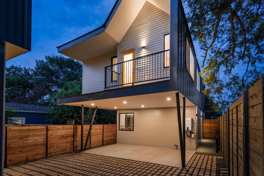 Rear view of house featuring a balcony, a patio area, and a fenced backyard