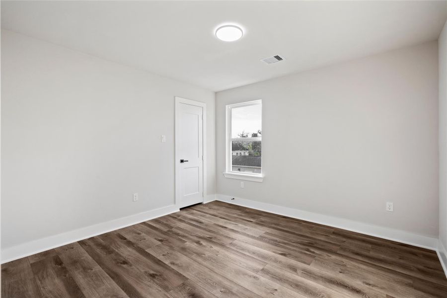 A bright secondary bedroom provides a clean, comfortable space that can easily flex for guests, a home office, or a creative room. With modern finishes and natural light, it feels fresh and move-in ready.