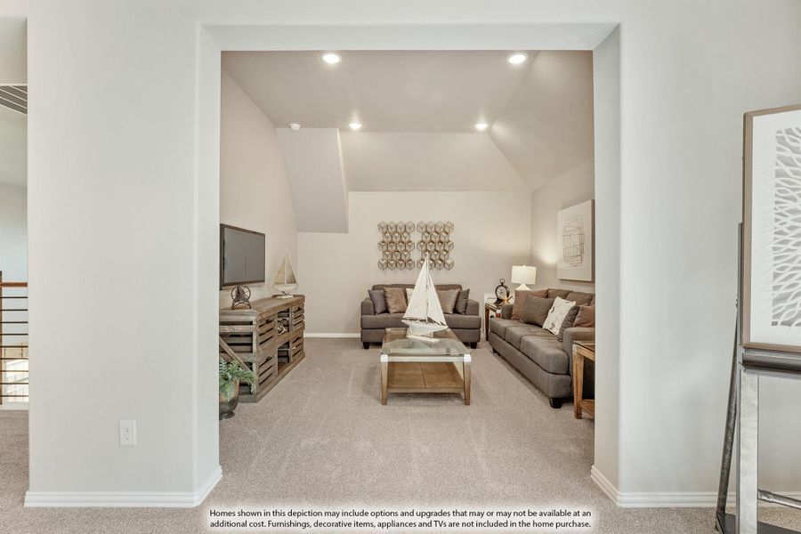 Living room with vaulted ceiling, gray sofas, carpet flooring, and recessed lighting viewed through wide doorway Living room with vaulted ceiling, gray sofas, carpet flooring, and recessed lighting viewed through wide doorway