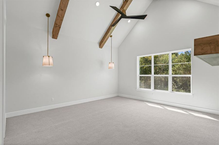 Empty room with high vaulted ceiling, carpet, beamed ceiling, a ceiling fan, and recessed lighting Empty room with high vaulted ceiling, carpet, beamed ceiling, a ceiling fan, and recessed lighting