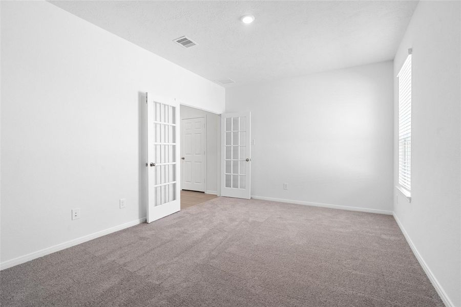 Additional view from the Den looking out to the double French doors. This versatile Den offers endless possibilities as a home office, gym, or playroom.