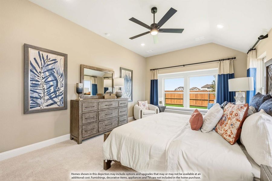 Bedroom with vaulted ceiling, ceiling fan, wood dresser, and large window with blue curtains