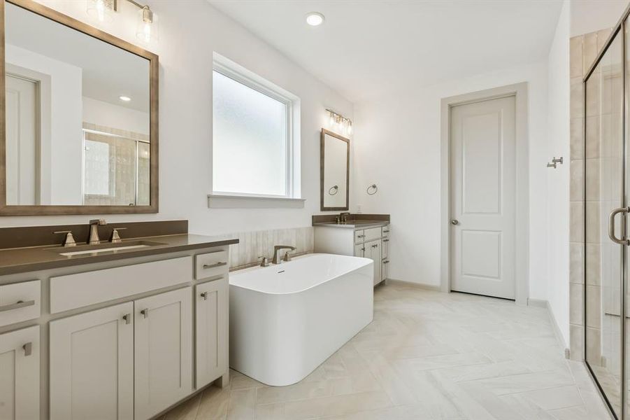 Featuring dual vanities, a free standing tub and spacious walk in shower, there is ample room for 2 in this dream owner's bath!