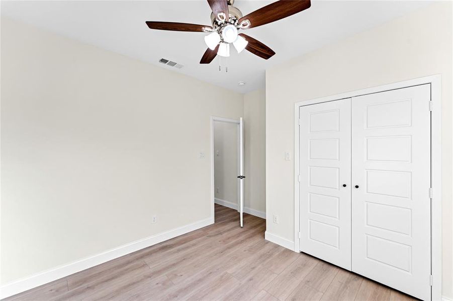 Unfurnished bedroom featuring ceiling fan, light hardwood / wood-style flooring, and a closet